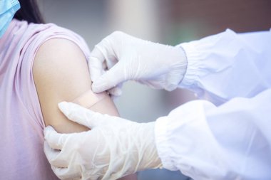 Medical Equipment, Soft focus Adhesive bandage on a female brachium after vaccination against Covid 19. First aid. Medical, pharmacy and healthcare concept.