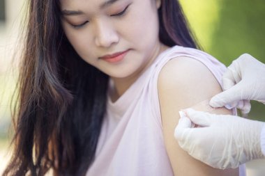 Medical Equipment, Soft focus Adhesive bandage on a female brachium after vaccination against Covid 19. First aid. Medical, pharmacy and healthcare concept.