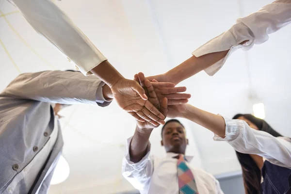 Close up view of young business people putting their hands together. Stack of hands. Unity and teamwork concept. Multiethnic College Students Stacking Hands