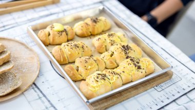 Mutfakta ekmek, ahşap masaya konmuş yemek malzemeleri, pişirmeye hazır. Metin için kopyalanma alanı. Yemek hazırlama kavramı, arka planda mutfak..