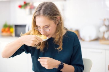 Kek ve kurabiye yapmak çok eğlencelidir. Mutfağında, genç bir kadın lezzetli taze ekmekler tutuyor..