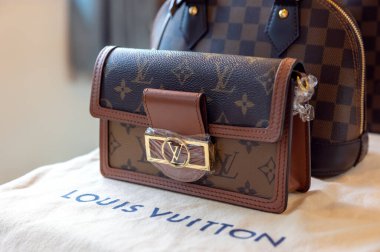 26 Temmuz 2021: Nakhon Prathom, THAILAND, Masanın üzerinde Louis Vuitton marka bir çanta ve başka bir marka var. Louis Vuitton, deri eşyalarda uzmanlaşmış lüks bir moda evi..