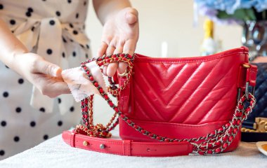 26 Temmuz 2021: Nakhon Prathom, THAILAND, Masada, bir kadın kırmızı Chanel çanta temizler.