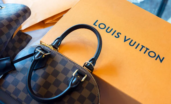 26 Temmuz 2021: Nakhon Prathom, THAILAND, Masanın üzerinde Louis Vuitton marka bir çanta ve başka bir marka var. Louis Vuitton, deri eşyalarda uzmanlaşmış lüks bir moda evi..