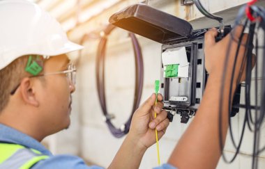 Bir internet teknisyeni fiber optik konnektör açarak fiber optik bağlantıyı tamir ediyor veya koruyor.