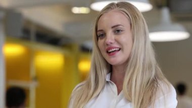 Genç ve güzel bir kadın kamerayla konuşuyor.