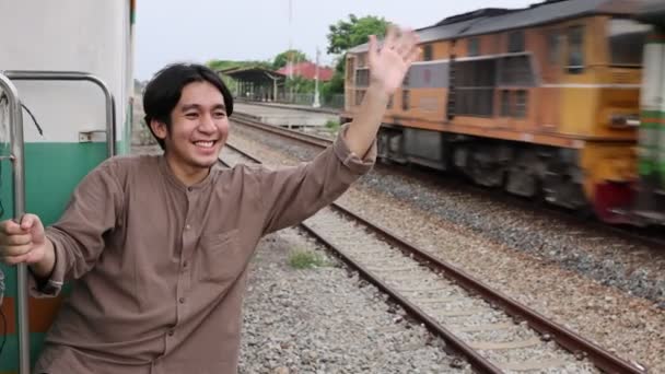Yakışıklı Asyalı Genç Adam Merhaba Demek Için Trendeki Arkadaşına Veda — Stok video