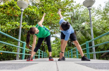 Köprüde, çekici genç bir fitness çifti esniyor, sportif bir erkek ve kadın birlikte egzersiz yapıyor..