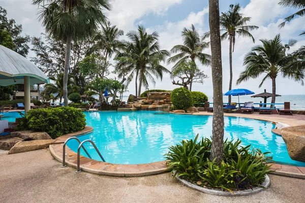 Piscine et palmiers au bord de la mer — Photo