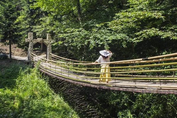 Senhora de chapéu em pé na ponte suspensa — Fotografia de Stock