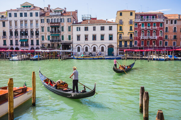 Tourists travel on gondolas at canal