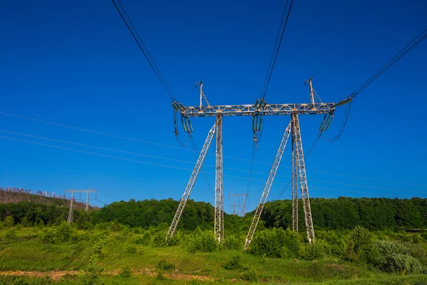 Linhas de energia no campo verde — Fotografia de Stock