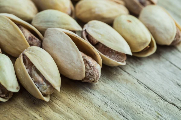 Pistachios heap on wooden boards — Stock Photo, Image