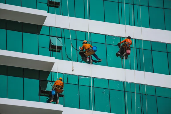 Pekerja membersihkan menara tinggi di kota besar — Stok Foto