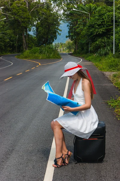 女孩带着手提箱废弃的道路上 — 图库照片