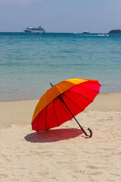 Orangefarbener Sonnenschirm am Strand — Stockfoto