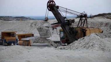 Ekskavatör bir kamyon taş ocağında yükler