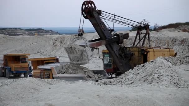 Pesado caminhão de despejo de mineração sendo carregado com minério de ferro — Vídeo de Stock