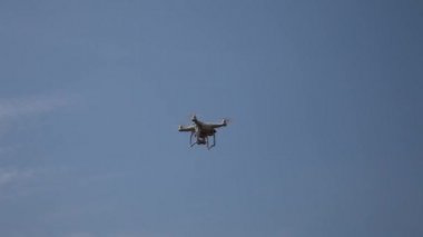 Çıkar - mavi gökyüzü karşı insansız hava aracı. Radyo kontrollü quadcopter yükselir. Dört motorlu uçak görünümü aşağıdan yukarıya