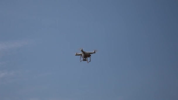 Descolagem - Veículo aéreo não tripulado contra o céu azul. O quadricóptero controlado por rádio sobe. Quad motor drone vista de baixo para cima — Vídeo de Stock