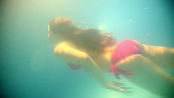 Mujer morena flotando bajo el agua — Vídeo de stock