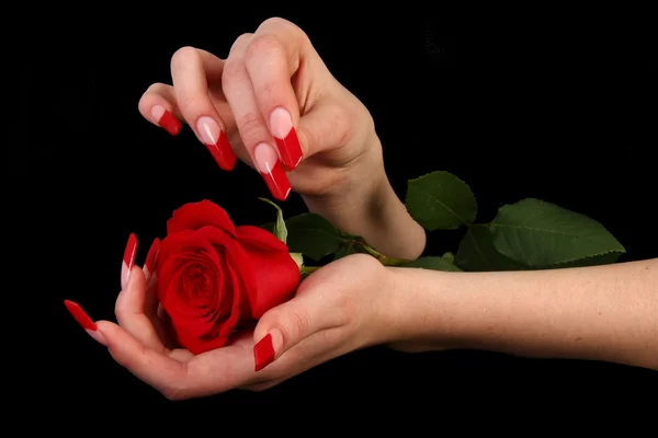 Hübsche Frau Hand mit perfekt lackierten Nägeln isoliert auf schwarzem Hintergrund Stockbild
