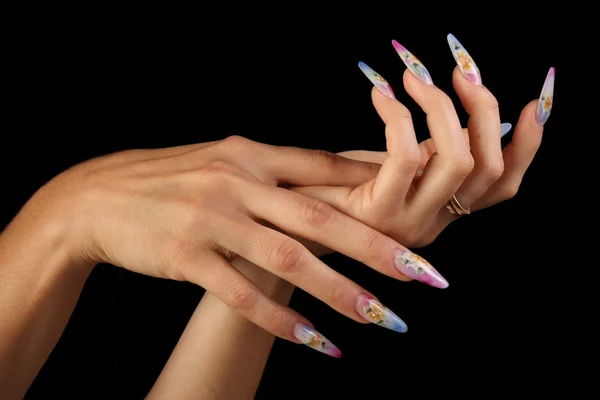 Hübsche Frau Hand mit perfekt lackierten Nägeln isoliert auf schwarzem Hintergrund lizenzfreie Stockbilder