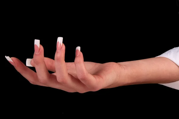 Hübsche Frau Hand mit perfekt lackierten Nägeln isoliert auf schwarzem Hintergrund lizenzfreie Stockfotos