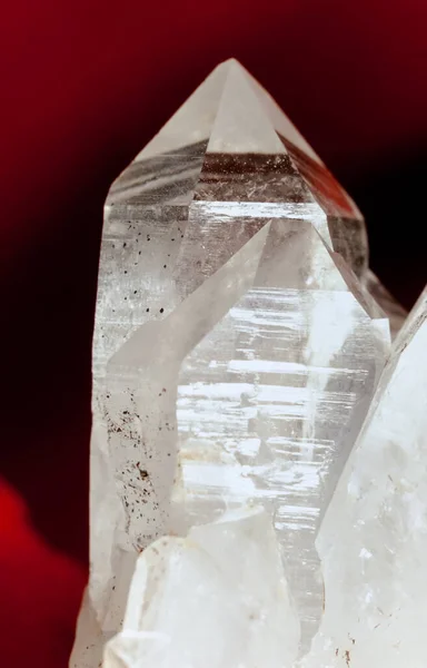 赤い背景にシリカ Sio2 の明確な多結晶品種である 岩石結晶または純粋な石英のクラスター この宝石は強い治癒力を持っていると言われています 4月の誕生石 — ストック写真