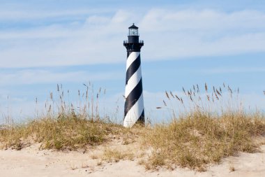 Cape Hatteras Lighthouse towers over beach dunes of Outer Banks island near Buxton, North Carolina, US clipart