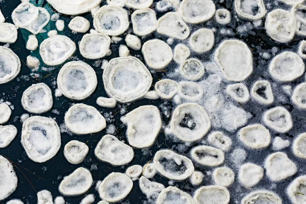 氷の背景のテクスチャ冬の霜の条件の間に穏やかに動く海の表面に形成される海氷のパンの性質パターン — ストック写真