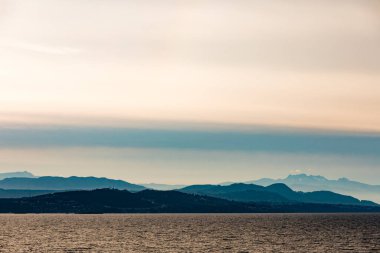 Vancouver Adası 'nın uzak doğu kıyıları. Orman tepeleri ve dağların silueti. Britanya Kolumbiyası, BC, Kanada Pasifik Okyanusu kıyıları sisle örtülü.