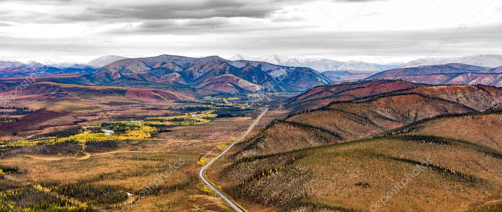 Engineer Creek valley and Dempster Highway in breathtaking autumn fall wilderness landscape seen from above on Sapper Hill, Yukon Territory, YT, Canada