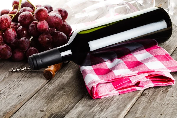 Botella de vino sacacorchos amd uvas en mesa de madera — Foto de Stock