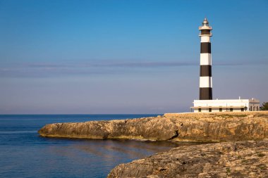 MINORCA ISLE - SPAIN - CIRCA AĞUSTOS 2020: Günbatımında manzaralı Artrutx Deniz Feneri, Adanın ünlü simgesi