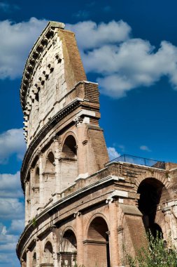 Roma, İtalya. Kolezyum 'un (Colosseo) dış kemerleri mavi gökyüzü arkaplanı ve bulutları.