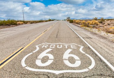Mavi gökyüzü arkaplanlı 66 numaralı yol tabelası. Kimsesiz tarihi bir cadde. Klasik bir seyahat ve macera konsepti..