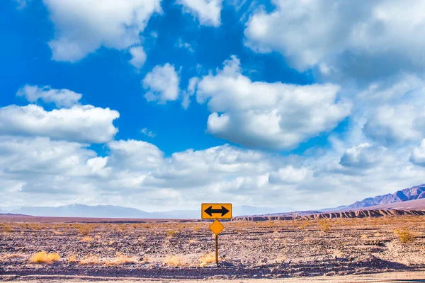 在有着蔚蓝的天空和广阔的地平线的沙漠中的方向性标志 假日和交通的概念 — 图库照片