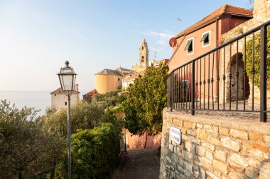 İtalya 'nın Liguria kentindeki ortaçağ köyü Cervo' nun manzarası, gün batımında renkli evlerin, kilise kulesinin ve Akdeniz manzarasının üzerine sıcak bir ışıkla çekildi..