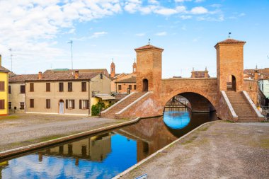 Comacchio, İtalya - 11 Haziran 2024: İtalyan kentinin tarihi sembolü ünlü Trepponti köprüsü. Liman manzarası