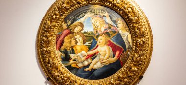 FLORENCE, ITALY Aralık 2025 Ziyaretçiler Magnificat 'ın Botticellis Madonna' sını altın çerçeveli meleklerle taçlandırılmış Bakire ve Çocuk 'u sergilenirken görüyorlar. Tarihi 1483, Uffizi Müzesi.