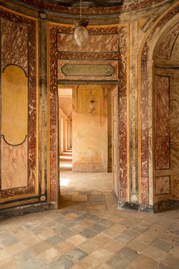 Agliè Kalesi 'nin iç görünümü, süslü boyanmış duvarlar, güneşli bir koridora açılan eski mermer dokular ve kapılar, İtalyan kraliyet mirasını ve mimarisini sembolize ediyor..