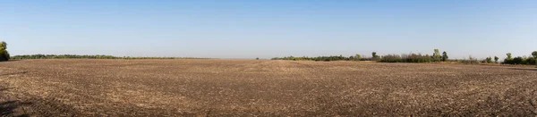 Panorama. Brown prázdné pole po sklizni na modrém pozadí oblohy — Stock fotografie