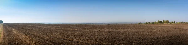 Panorama. Sonbahar manzarası, mavi gökyüzü arka planında hasattan sonra siyah boş tarla — Stok fotoğraf