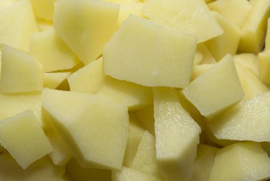 Patatesler sarı parçalara bölünmüş, doku arkaplanı.