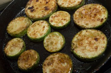 Taze balkabağını kızartırken tavada doğranmış daireler. Kavunla yemek pişirmek..