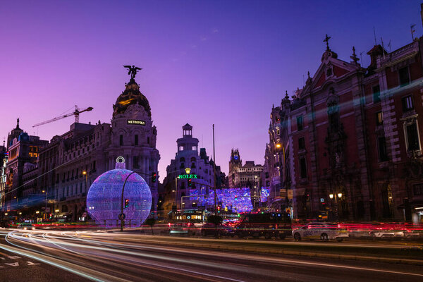 MADRID, SPAIN - JANUARY 4, 2020: Night view of Madrid Alcala and Gran Via streets illuminated by the traffic and the Christmas decorations.
