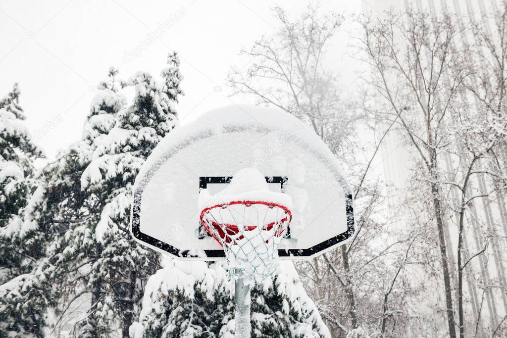 Front view of a street basketball hoop under the snow during the heavy Filomena storm in Madrid, Spain.