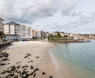 SANXENXO, İspanya - 21 Mayıs 2021: Galiçya, Rias Baixas 'ta bulutlu bir bahar gününde Sanxenxo ve Panadeira plajlarının geniş açılı görüntüsü.