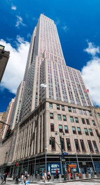 NEW YORK - 19 Mayıs 2024: New York City 'nin en ikonik simgelerinden biri olan Empire State Binası' nın yukarı doğru görüntüsü Manhattan 'ın merkezindedir. Işıl ışıl mavi gökyüzü ile aydınlık bir günde çekilen görüntü, yükselen tepeleri vurguluyor.